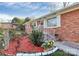 Close-up of the home's entrance showcasing brickwork, white trim and colorful front yard flowerbeds at 213 Turner Rd, Gastonia, NC 28056