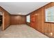 Cozy living room featuring carpeted floors, wood paneling, and natural light from the windows at 213 Turner Rd, Gastonia, NC 28056