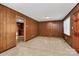 Cozy living room with wood paneling, neutral carpet, and natural light from the window at 213 Turner Rd, Gastonia, NC 28056