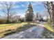 Wide shot showing large trees, expansive yard, and house, framed by a chain link fence at 213 Turner Rd, Gastonia, NC 28056