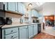 An efficient kitchen design features light-blue cabinets, a window, and modern appliances at 230 Valley View Dr, Clover, SC 29710