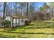 Exterior view of storage shed with double doors and mossy roof, surrounded by lush greenery and trees at 230 Valley View Dr, Clover, SC 29710