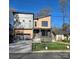 Modern two-story home featuring a unique facade, gray garage door, and a well-manicured front lawn at 2421 Barry St, Charlotte, NC 28205