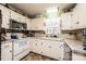 Cozy kitchen with white cabinets, appliances, window, and tile floors at 2561 Ellys St, Lincolnton, NC 28092