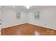 Sunlit bedroom showcasing hardwood floors, light walls, and two windows at 2750 Morgan Rd, Gold Hill, NC 28071