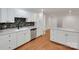 Bright kitchen with white cabinets, stainless steel appliances, backsplash and wood floors at 2750 Morgan Rd, Gold Hill, NC 28071