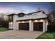 Stylish three-car garage featuring contemporary dark doors in a modern white home at 2924 Springs Dr, Charlotte, NC 28226