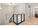 Hallway featuring modern lighting fixture, modern railings, and an entrance into another room at 2924 Springs Dr, Charlotte, NC 28226