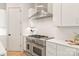 Kitchen featuring stainless steel gas range, white cabinets and countertops with stylish backsplash at 2924 Springs Dr, Charlotte, NC 28226