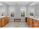 Large bathroom with double vanity, wood cabinets, and multiple windows for natural light at 3203 Thayer Dr, Waxhaw, NC 28173