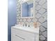 Stylish powder room featuring blue patterned walls, a white vanity, and modern fixtures at 3203 Thayer Dr, Waxhaw, NC 28173