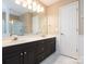 Bathroom featuring double sinks, dark cabinets, white countertops, and a framed mirror at 3274 Roberta Farms Sw Ct, Concord, NC 28027