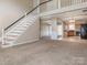 Spacious living room with an open staircase leading to the second floor, and views into the dining and kitchen areas at 3274 Roberta Farms Sw Ct, Concord, NC 28027