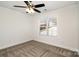 Neutral bedroom with a ceiling fan, plush carpet, and a large window offering natural light at 329 Gurley Nw Dr, Concord, NC 28027