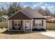 Charming one-story home with light gray siding, front porch, and green fence at 329 Gurley Nw Dr, Concord, NC 28027