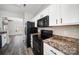 Stylish kitchen featuring white cabinets, black appliances, and granite countertops at 4221 Coulter Xing, Charlotte, NC 28213