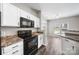 Modern kitchen with white cabinetry, black appliances, and wood-look flooring at 4221 Coulter Xing, Charlotte, NC 28213