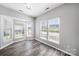 Bright living room featuring multiple windows, wood flooring, and a modern light fixture at 4221 Coulter Xing, Charlotte, NC 28213