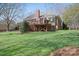 Green backyard featuring a deck, brick exterior, mature trees, and a well-kept lawn at 4300 Pointe Norman Dr, Sherrills Ford, NC 28673