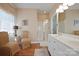 Well-lit bathroom featuring a double sink vanity, glass shower, and decorative seating area by the window at 4300 Pointe Norman Dr, Sherrills Ford, NC 28673