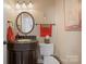 Elegant powder room with dark wood vanity, oval mirror, and decorative accents at 4300 Pointe Norman Dr, Sherrills Ford, NC 28673