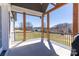 Scenic back porch with wooden columns and black railings overlooking a lush green lawn and wooded landscape at 4412 Holly Ne Cir, Conover, NC 28613