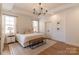 Serene bedroom with tray ceilings, a light-colored rug and bench at the foot of the bed at 4412 Holly Ne Cir, Conover, NC 28613