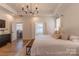 Bright main bedroom featuring a modern chandelier, hardwood floors, and access to an ensuite bathroom at 4412 Holly Ne Cir, Conover, NC 28613