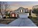 Charming two-story home with a brick accent, a well-manicured lawn, and a spacious driveway at dusk at 4513 Staffordshire Ln, Charlotte, NC 28213