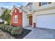 Home exterior with front entrance, brick accents, a well-manicured yard, and a two-car garage at 4513 Staffordshire Ln, Charlotte, NC 28213