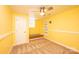 Bright yellow basement featuring neutral carpeting, a window bench, and ceiling fan at 4846 Midway Sand Rd, Hickory, NC 28601