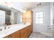 Bright bathroom featuring a double vanity, a large mirror, and a glass-enclosed shower at 4846 Midway Sand Rd, Hickory, NC 28601