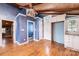 Bright living room with hardwood floors, wood ceiling, a ceiling fan, and blue accent walls, exuding rustic charm at 4846 Midway Sand Rd, Hickory, NC 28601