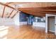 Open-concept living room with wood floors, exposed beams, and a kitchen featuring white cabinets with modern appliances at 4846 Midway Sand Rd, Hickory, NC 28601