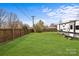 Backyard with a large lawn, a trailer on the right, and a tall fence at 5140 Old Monroe Rd, Indian Trail, NC 28079