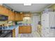 Well lit kitchen featuring wood cabinets and white appliances at 5140 Old Monroe Rd, Indian Trail, NC 28079