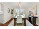 Formal dining room with large window, hardwood floors, white accent chairs and modern decor at 5217 Camilla Dr, Charlotte, NC 28226