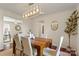 Bright dining room features modern light fixture and wood table with seating for six at 5217 Camilla Dr, Charlotte, NC 28226