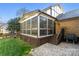 Exterior view of a brick home's screened-in porch with brick patio and well-kept yard at 5217 Camilla Dr, Charlotte, NC 28226