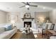 Bright living room featuring a white painted brick fireplace, a ceiling fan, and neutral decor at 5217 Camilla Dr, Charlotte, NC 28226