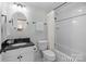 Bathroom featuring classic black and white tile, shower with curtain, and round mirror at 643 Mcalway Rd, Charlotte, NC 28211