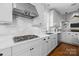 Stylish kitchen with stainless steel vent hood and a cooktop on a white quartz countertop at 643 Mcalway Rd, Charlotte, NC 28211