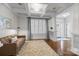 Cozy living room featuring a modern leather sofa, coffered ceiling, and shuttered windows at 643 Mcalway Rd, Charlotte, NC 28211