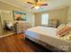 Bedroom featuring wood-look floors, neutral wall colors, mirror, and a large bed at 7025 Spring Morning Ln, Charlotte, NC 28227