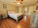 Bedroom showcasing a ceiling fan, wood-look floors, and ensuite bathroom at 7025 Spring Morning Ln, Charlotte, NC 28227