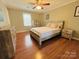 Comfortable bedroom with wood-look flooring, ceiling fan, and rustic wood furniture at 7025 Spring Morning Ln, Charlotte, NC 28227