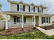 Charming two-story home featuring a welcoming front porch with decorative hanging flower baskets at 7025 Spring Morning Ln, Charlotte, NC 28227