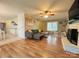 Bright living room featuring hardwood floors, a brick fireplace, and access to the backyard at 7025 Spring Morning Ln, Charlotte, NC 28227