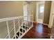 Staircase boasts hardwood floors and white railing leading to the second floor at 7025 Spring Morning Ln, Charlotte, NC 28227