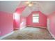 A bedroom with pink painted walls, carpeted floors, and a single window requires repairs and updates at 82 Paddington Sw Dr, Concord, NC 28025